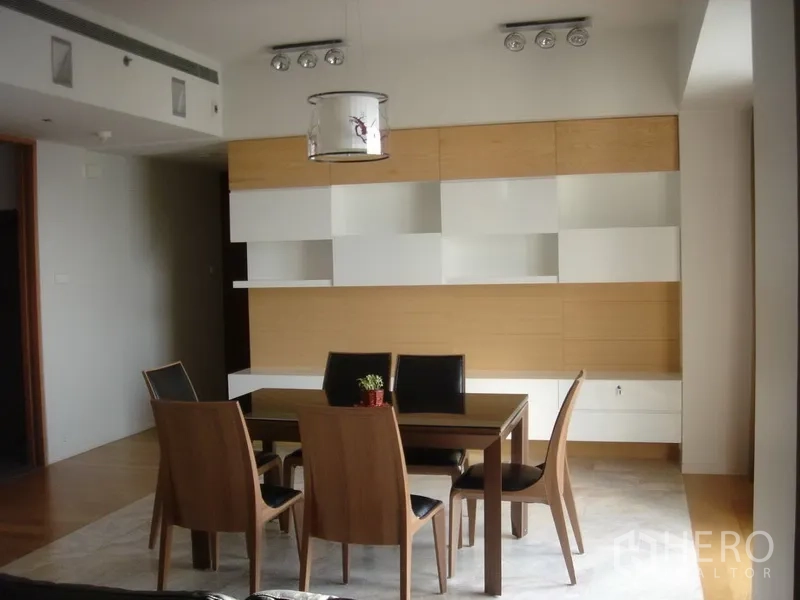 Condominium for rent in Sathon, Bangkok - Six-seat dining area with modern pendant light and white-and-wood built-in cabinets.
