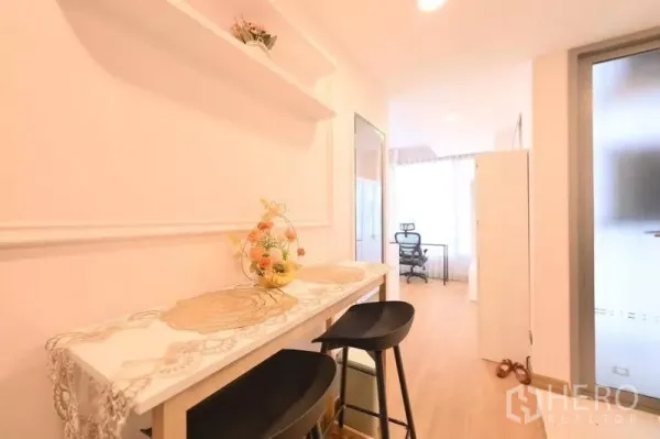 公寓 出租在Watthana, Bangkok - 紧凑吧台配两把高脚凳与置物架，通向明亮工作区。