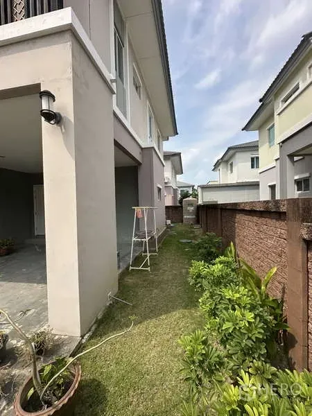 Detached House for sale in Sai Mai, Bangkok - Narrow side garden with lawn and shrubs beside the house.