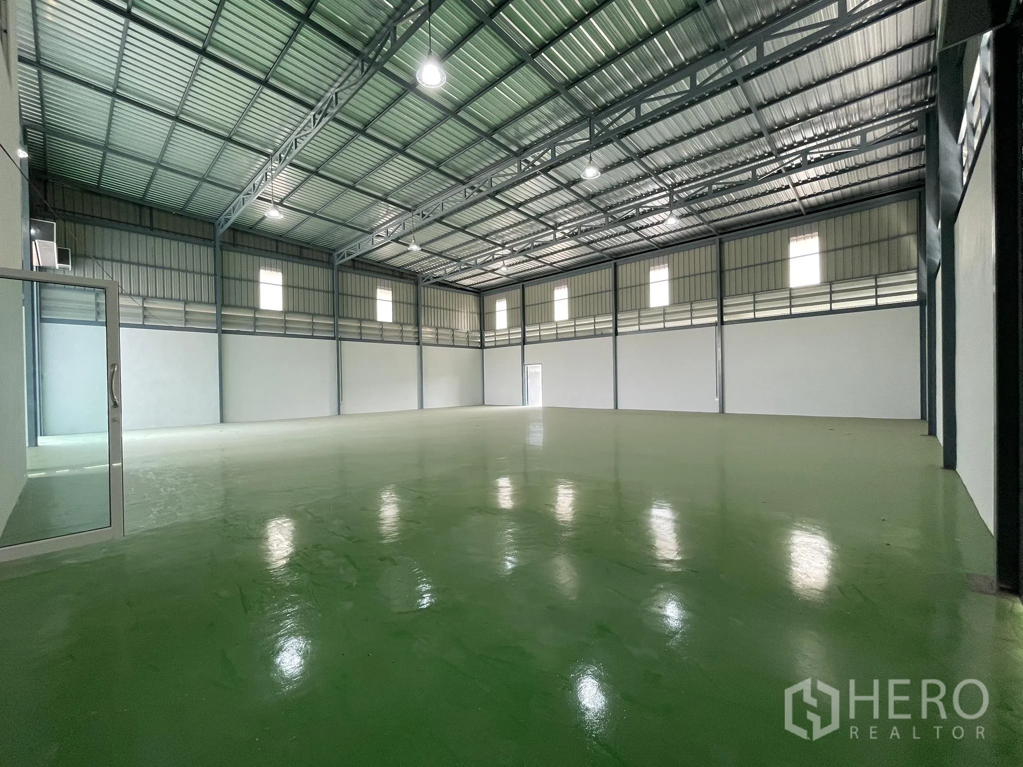 Factory for rent or sale in Bang Phli, Samut Prakan - High-ceiling warehouse hall with steel structure and green epoxy floor.