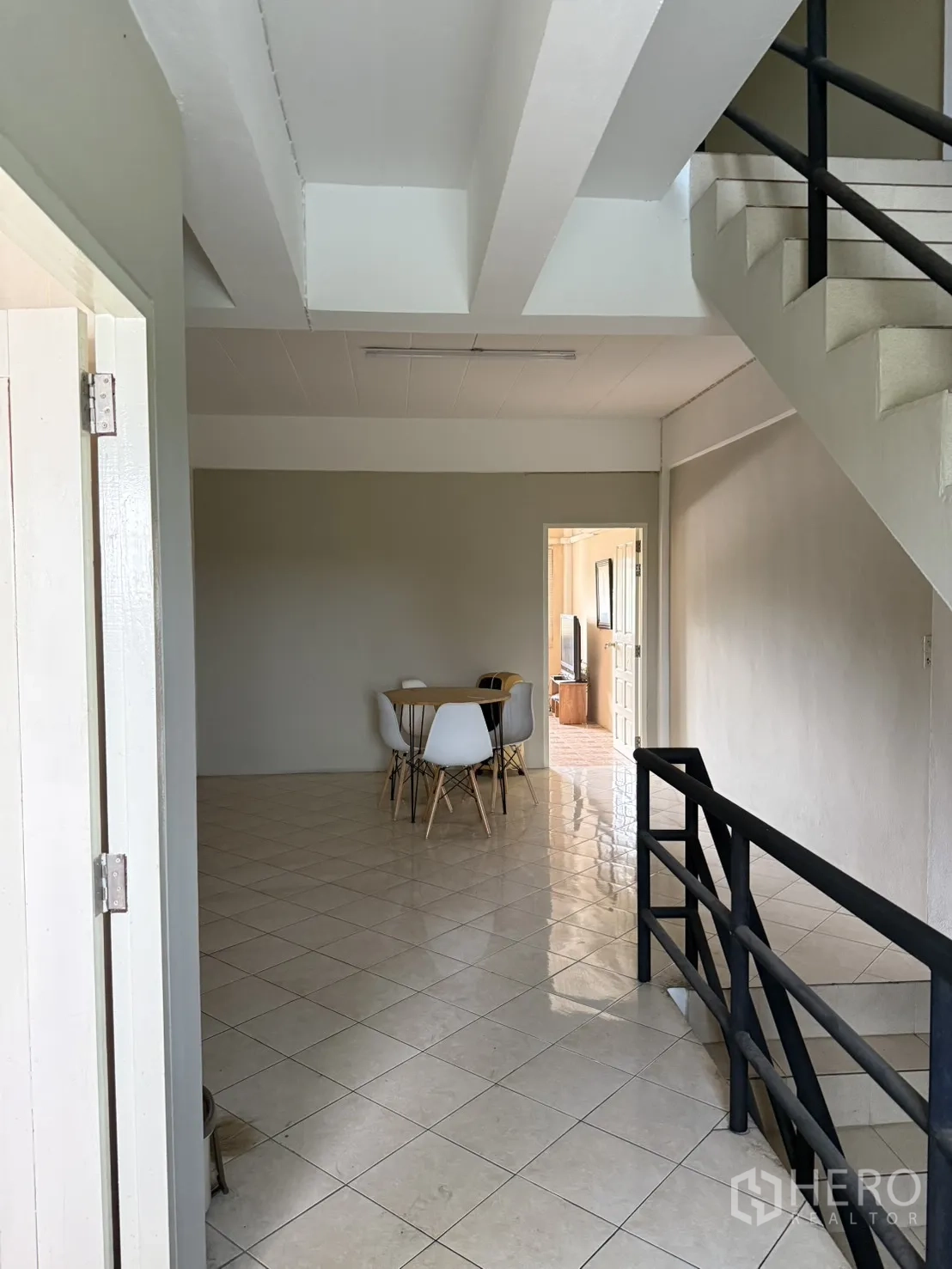 Shophouse for rent in Pak Kret, Nonthaburi - Stairwell opening to a bright dining area with table and chairs.