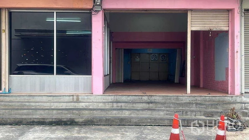 零售空间 出租在Bang Na, Bangkok - 店铺入口台阶与开放门洞，卷闸门旁为大型展示窗。