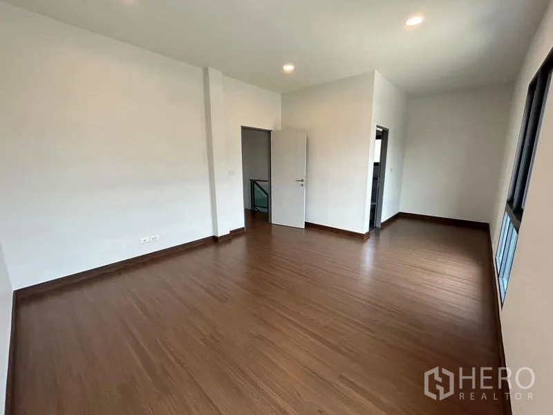 Detached House for rent - Spacious bedroom with wood floors, multiple windows, and door to ensuite.