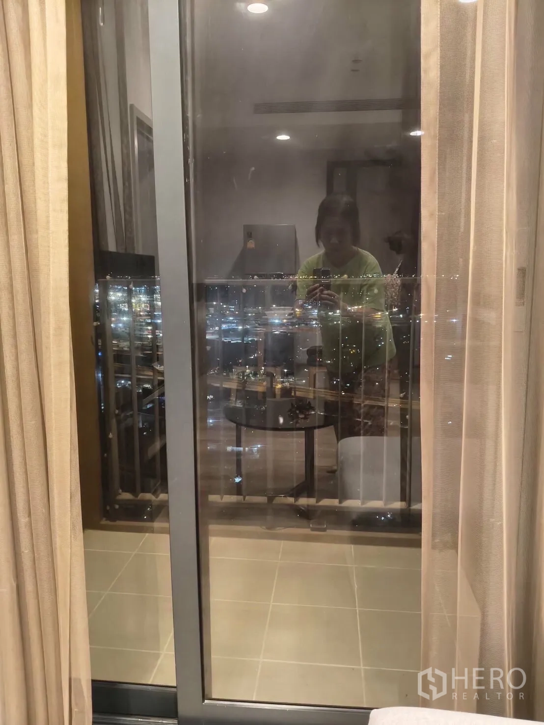 Condominium for rent in Khlong Toei, Bangkok - Sliding glass door revealing a night city skyline from the living area.