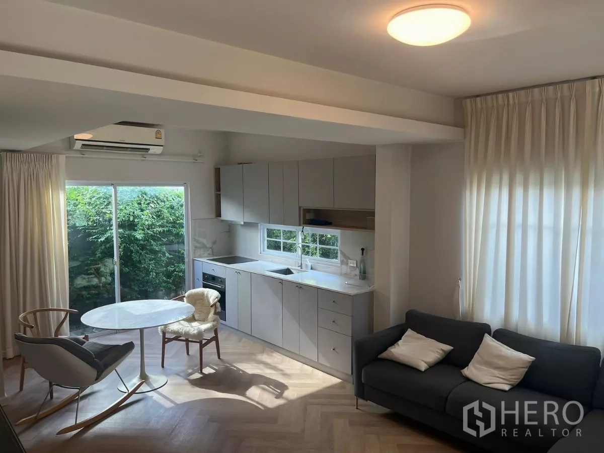 Townhouse for rent in Bang Phli, Samut Prakan - Wide shot of open-plan lounge and kitchen filled with soft natural light.