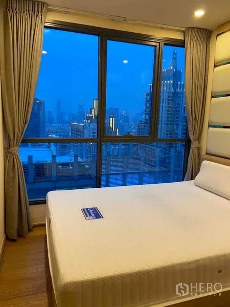 公寓 出租或出售在Ratchathewi, Bangkok - 卧室设大窗，欣赏夜色城市景观。