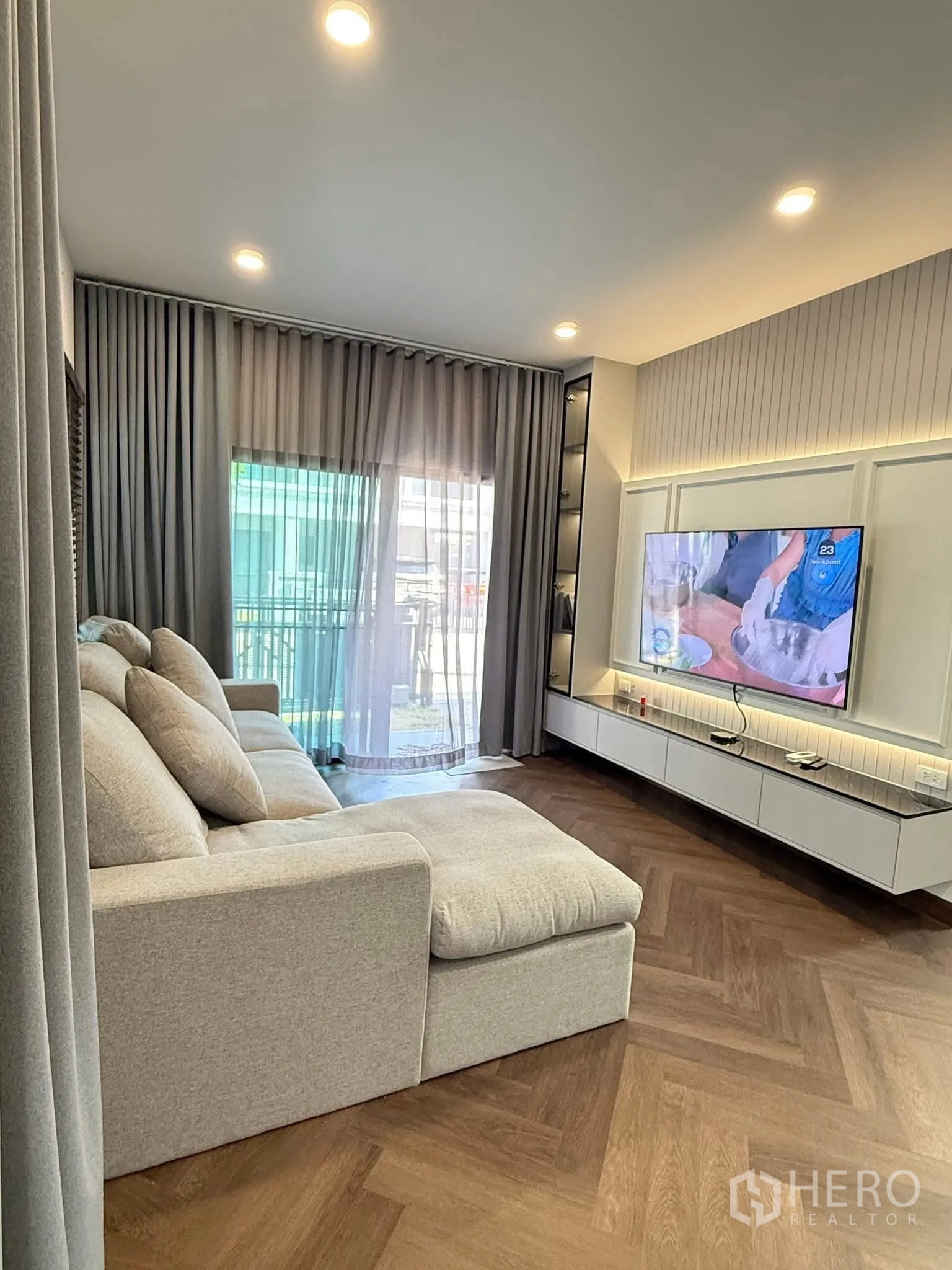 独栋房屋 for rent in Bang Phli, Samut Prakan - 客厅设L型沙发，推拉玻璃门与纱帘。