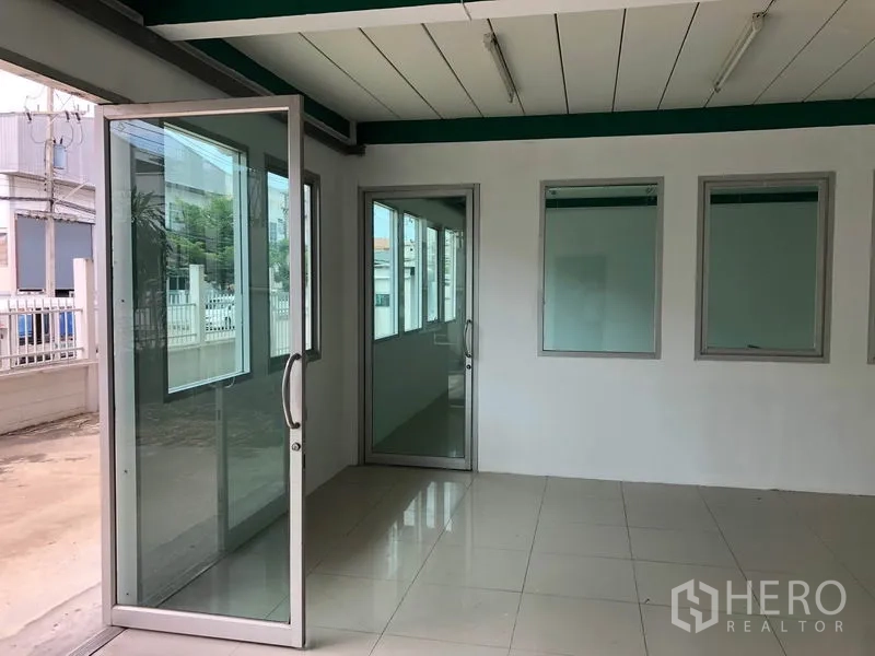 工厂 出租在Lam Luk Ka, Pathum Thani - 一层办公室入口，玻璃推门与亮面地砖
