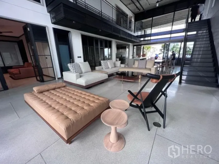 Condominium for rent in Sathon, Bangkok - Double-height living room with floor-to-ceiling windows, neutral sofas and modern lounge seating.