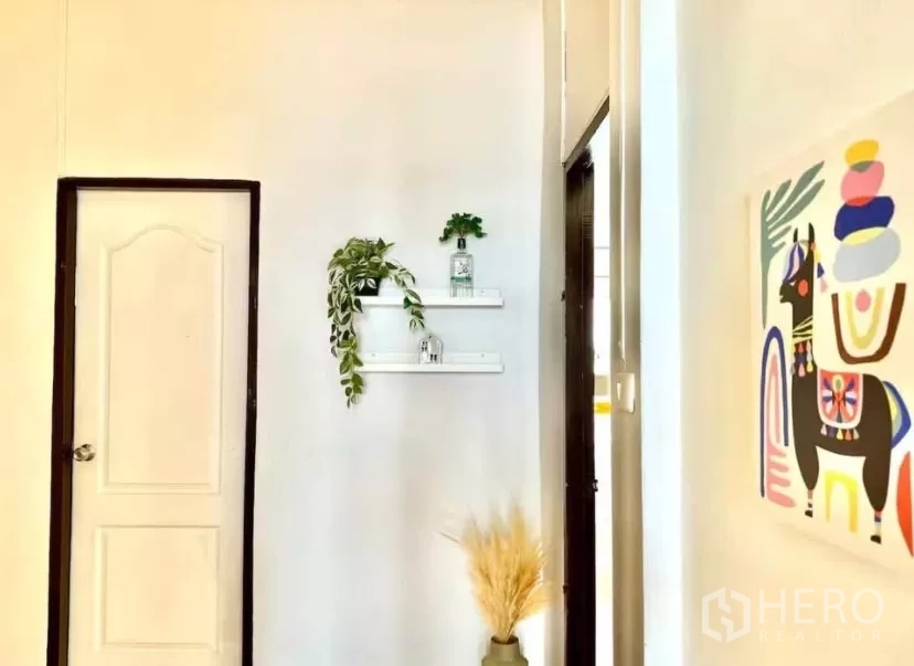 联排别墅 出租在Watthana, Bangkok - 走廊角落，壁架、绿植与彩色装饰画