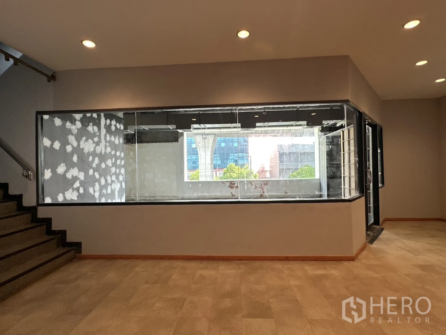 พื้นที่ขายของ for rent in Watthana, Bangkok - พื้นที่ภายในมีผนังกระจกบานใหญ่ ไฟฝังฝ้า และบันไดขึ้นลง.