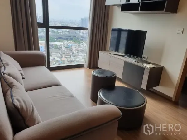 公寓 出租在Watthana, Bangkok - 客厅配沙发与电视柜，落地窗可眺望曼谷市景。