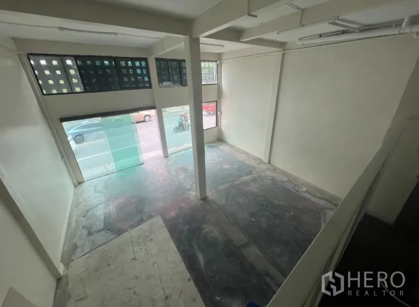 店屋 出租在Watthana, Bangkok - 前厅挑高空间，临街大窗与承重柱。