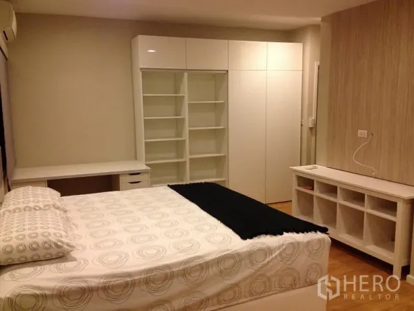คอนโด ให้เช่าในPathum Wan, Bangkok - มุมห้องนอนใหญ่ พร้อมชั้นวางบิลต์อิน โต๊ะทำงาน และตู้เสื้อผ้าสีขาว