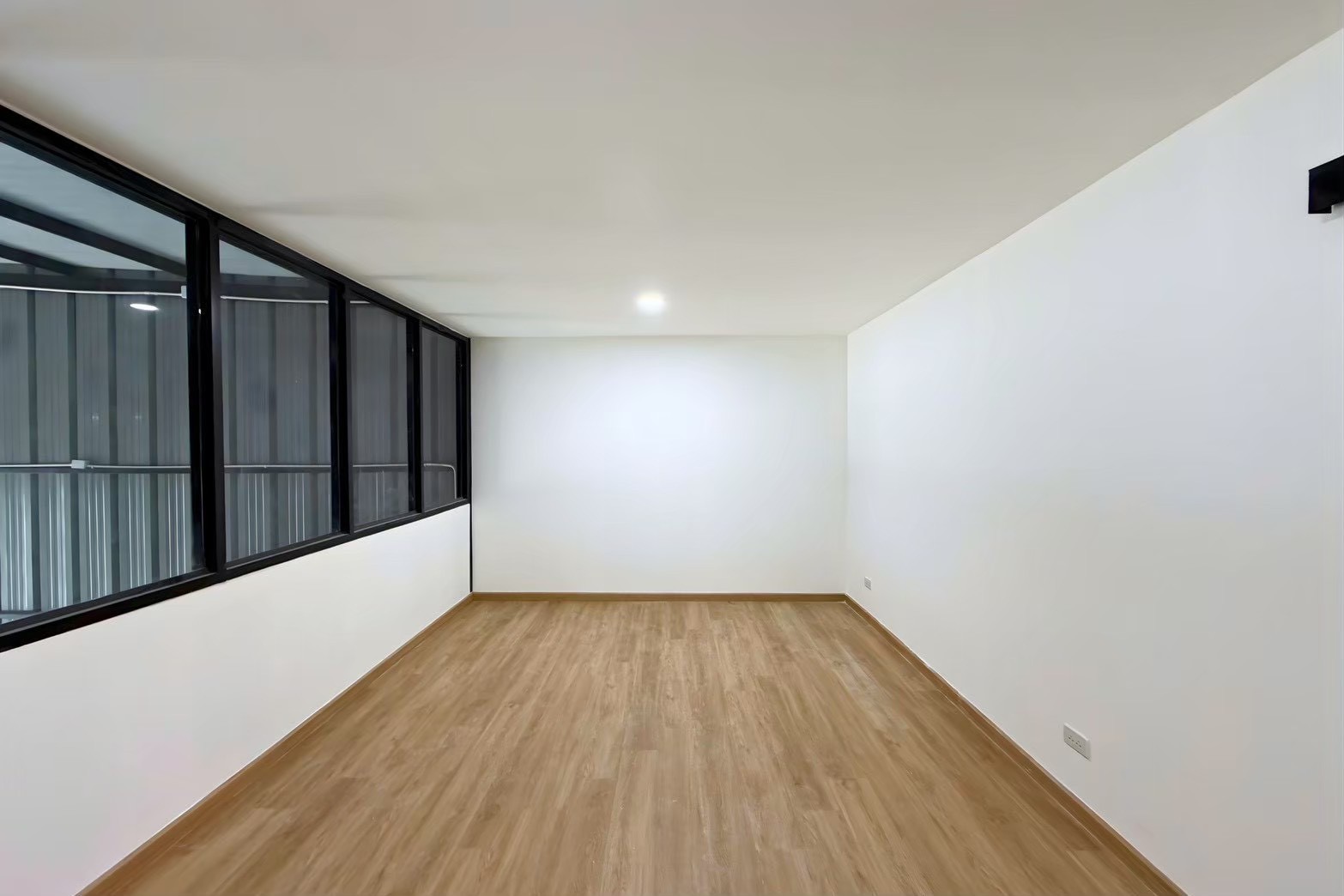 Warehouse for rent in Bang Phli, Samut Prakan - Glass-partitioned mezzanine office with wood-style flooring and white walls inside the warehouse.