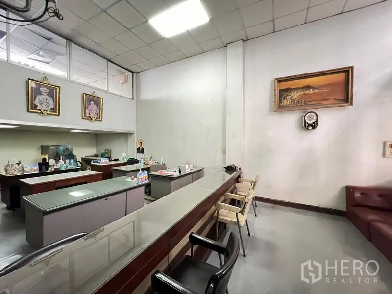Shophouse for sale - Open office zone with long service counter and multiple desks.