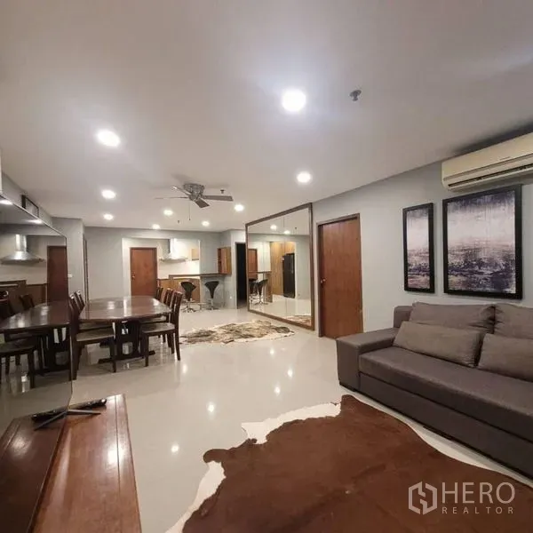 公寓 出租在Watthana, Bangkok - 宽敞起居区，远眺厨房与餐桌，嵌灯明亮。