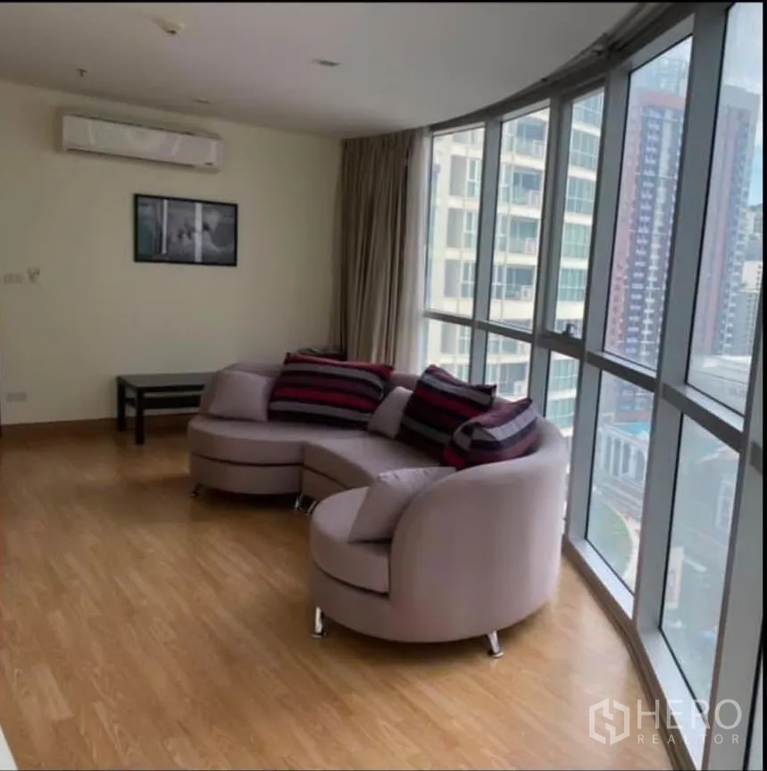 คอนโด ให้เช่าในWatthana, Bangkok - ห้องนั่งเล่นสว่าง โซฟาทรงโค้งติดหน้าต่างกระจกเต็มบาน มองเห็นวิวเมือง