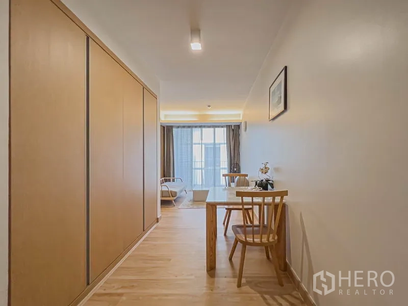 公寓 出售在Watthana, Bangkok - 入口走廊设整排衣柜与双人餐桌，通往客厅与玻璃门。