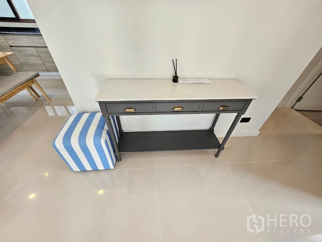 Detached House for rent in Bang Kapi, Bangkok - Entry console table with striped ottoman on glossy tiled floor.