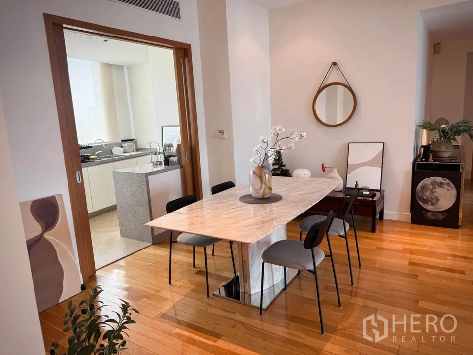 Condominium for rent or sale in Khlong Toei, Bangkok - Dining area with marble table and sliding doors opening to the kitchen.