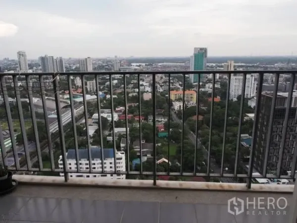 Condominium for rent in Khlong Toei, Bangkok - Condo balcony with safety railing overlooking Bangkok cityscape from above.