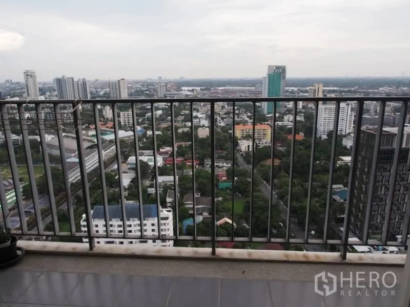 Condominium for rent in Khlong Toei, Bangkok - Condo balcony with safety railing overlooking Bangkok cityscape from above.