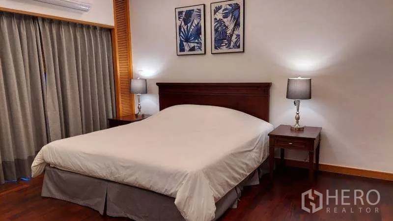 Apartment for rent - Bedroom with king bed, twin bedside lamps and blue botanical artwork.