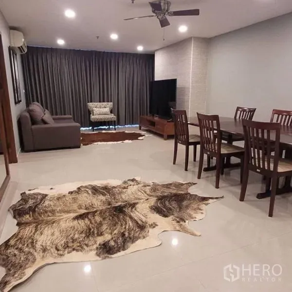 公寓 出租在Watthana, Bangkok - 开放式客餐厅，吊扇、电视柜与牛皮地毯。