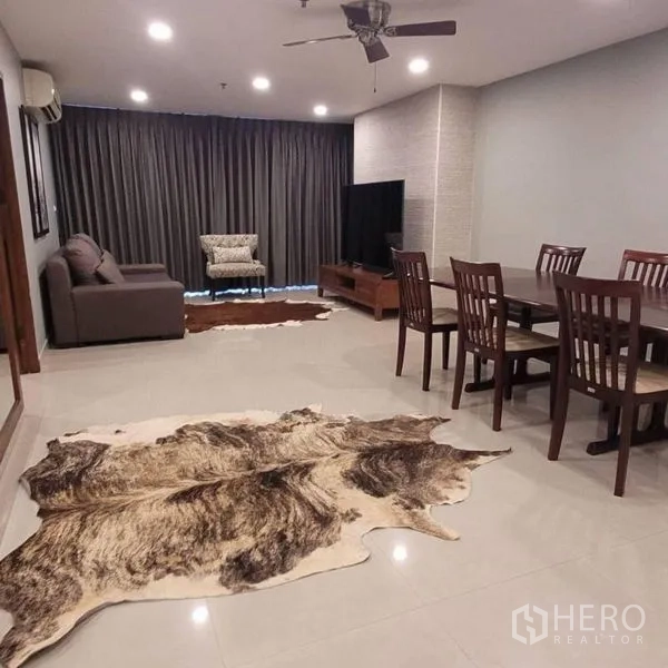 公寓 出租在Watthana, Bangkok - 开放式客餐厅，吊扇、电视柜与牛皮地毯。