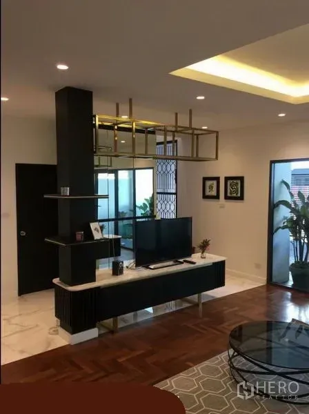 联排别墅 出租在Khlong Toei, Bangkok - 客厅一角，电视柜与装饰隔断，嵌入式顶灯