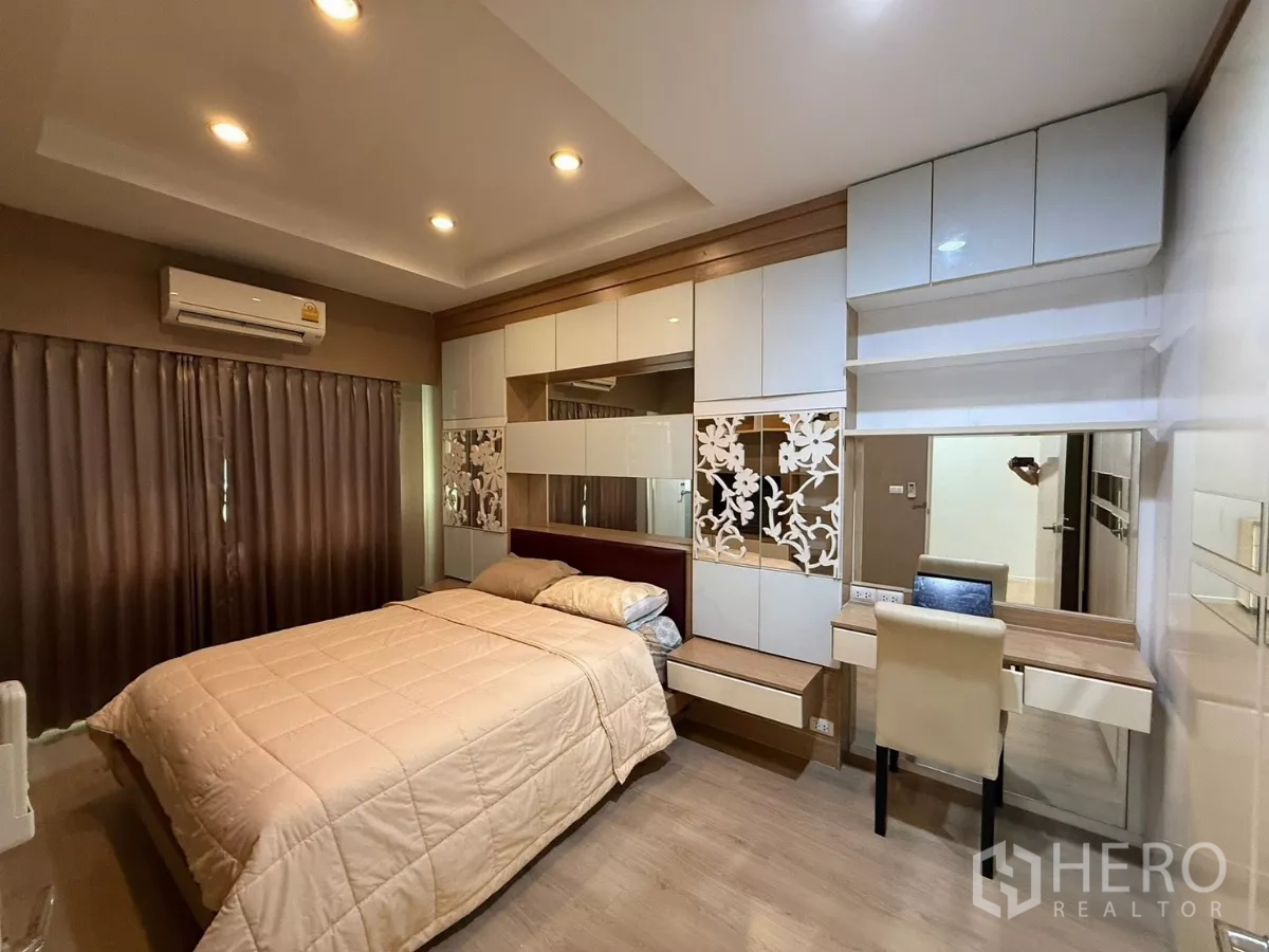 Townhouse for rent in Suan Luang, Bangkok - Second bedroom with built-in wardrobes, work desk and warm lighting.