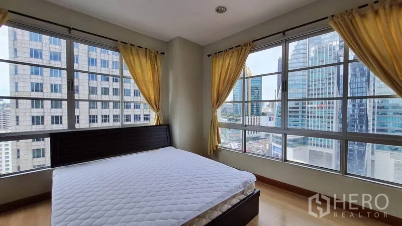公寓 出租在Khlong Toei, Bangkok - 转角卧室，环幕窗尽览曼谷天际线。