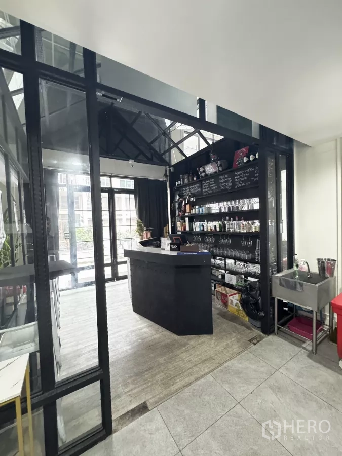 店屋 出租在Khlong Toei, Bangkok - 服务吧台配陈列架摆放酒具与杯具，旁设整面落地窗。