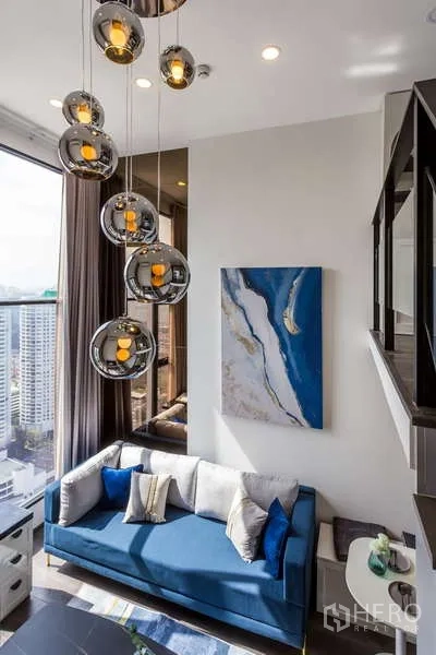 Condominium for rent - Double-height lounge with modern pendant lights and large city-view windows.