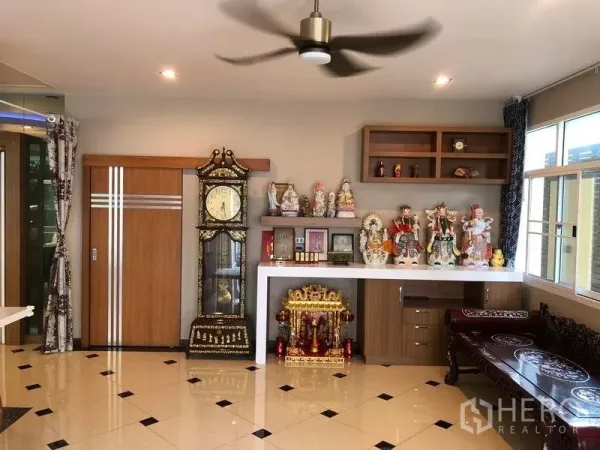 Detached House for sale in Wang Thonglang, Bangkok - Living space with display shelves, a tall clock and glossy tiled flooring.