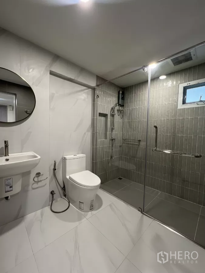 Detached House for rent in Saphan Sung, Bangkok - Modern bathroom featuring large walk-in shower with gray tiles and rainfall head.