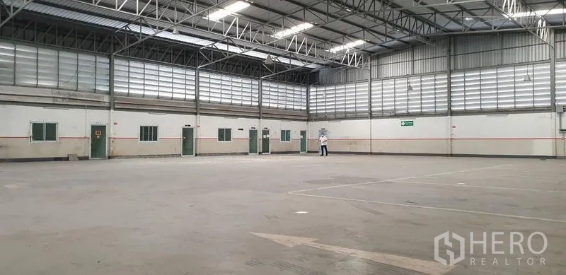 Warehouse for rent in Lam Luk Ka, Pathum Thani - Front entrance view of the warehouse complex with gated access and off-street parking.