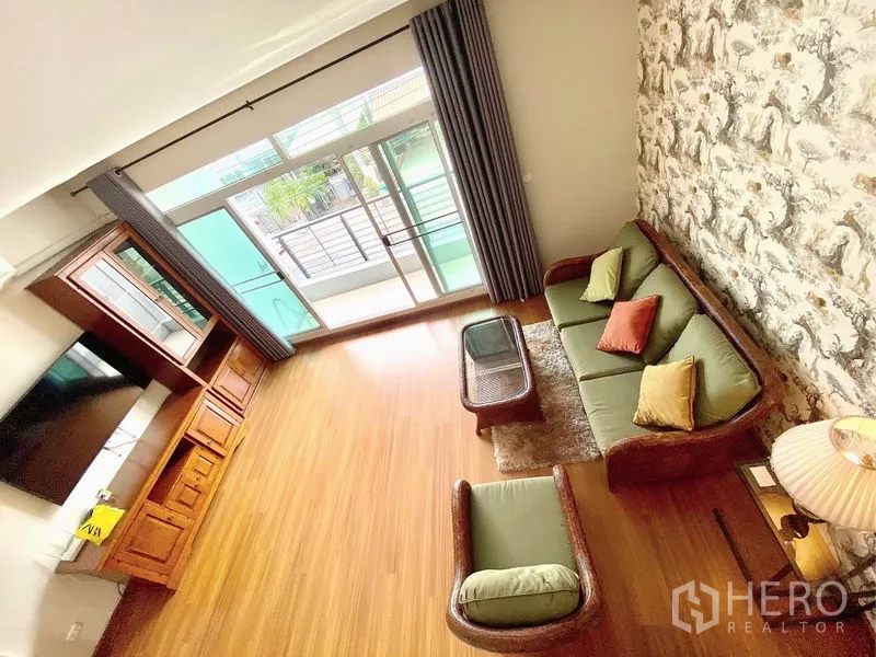 联排别墅 出租在Prawet, Bangkok - 楼上家庭起居室，藤编沙发套组，落地推拉门通阳台