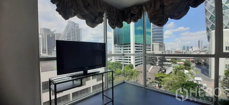 Condominium for rent in Phaya Thai, Bangkok - Corner room with floor-to-ceiling windows, a TV stand and sweeping city skyline views.