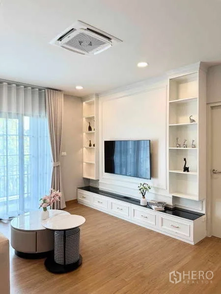 บ้าน ให้เช่าหรือขายในBang Phli, Samut Prakan - ห้องครอบครัวผนังทีวีพร้อมชั้นโชว์ พื้นไม้ ประตูกระจกบานเลื่อน และแอร์ฝังฝ้า