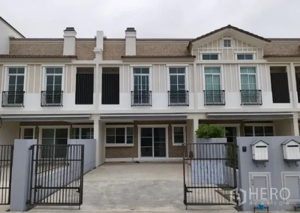 联排别墅 出租在Prawet, Bangkok - 两层联排别墅外立面，带阳台与双车位铁门车道。