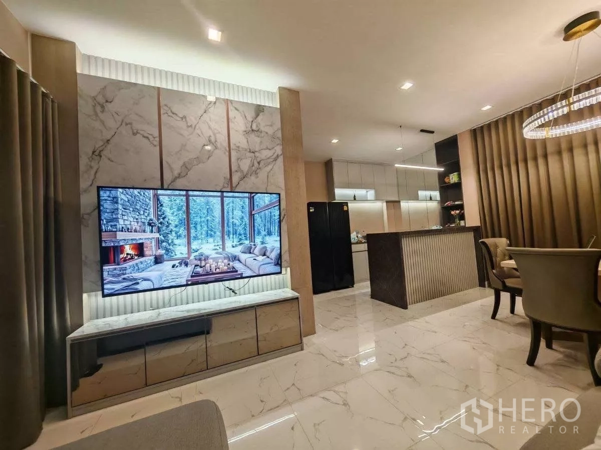 独立式住宅 出租在Bang Phli, Samut Prakan - 开放式客厅，仿大理石地面，电视背景墙与吧台相连。