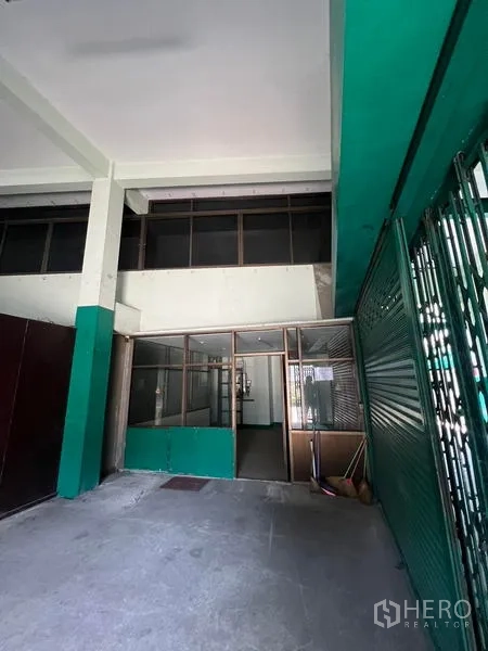 Warehouse for rent in Bang Kho Laem, Bangkok - Ground-floor loading zone with roller shutter and glass office booth.