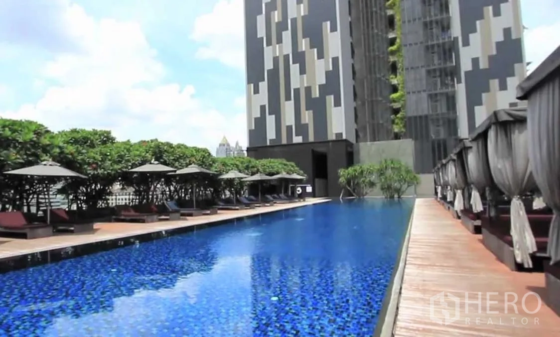 Condominium for sale in Sathon, Bangkok - Condominium outdoor lap pool with sun loungers, cabanas and landscaped deck.