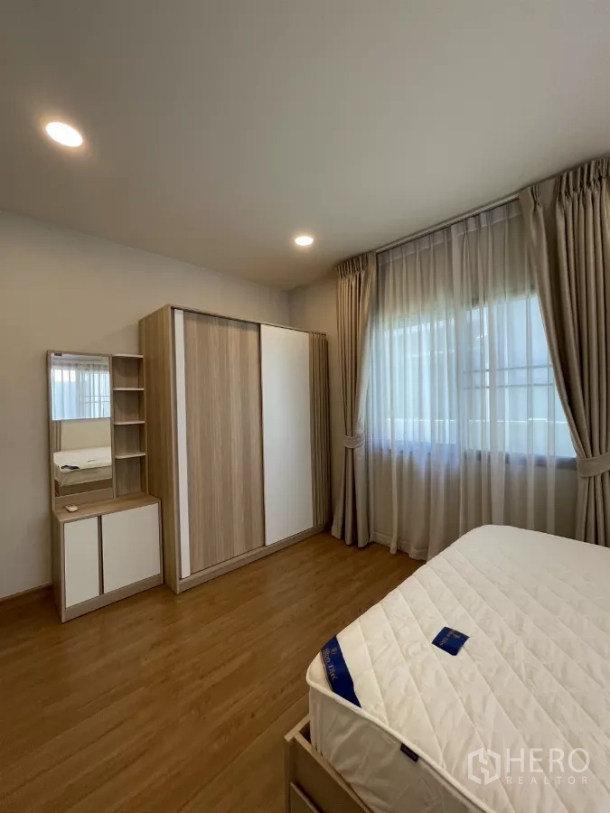 独立式住宅 出租在Bang Phli, Samut Prakan - 卧室角落的衣柜和梳妆柜，配大窗。