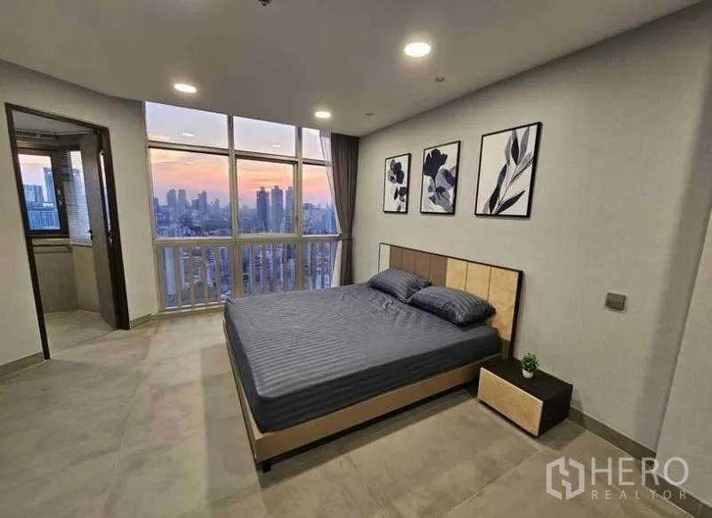 Condominium for rent or sale - Corner bedroom with floor-to-ceiling windows overlooking the skyline.
