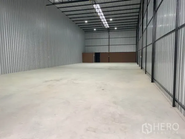 货栈 出租在Khlong Luang, Pathum Thani - 仓库内部空间开阔，钢构高挑屋顶，天窗带LED照明，混凝土地面平整。