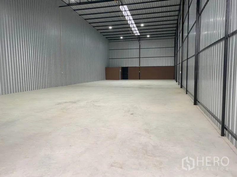 货栈 出租在Khlong Luang, Pathum Thani - 仓库内部空间开阔，钢构高挑屋顶，天窗带LED照明，混凝土地面平整。