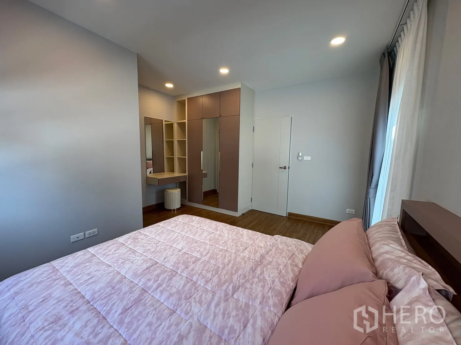 บ้าน for rent in Bang Phli, Samut Prakan - ห้องนอนอีกห้องตกแต่งชุดผ้าสีชมพู มีโต๊ะเครื่องแป้งมุมห้อง ตู้เสื้อผ้าบิลท์อิน และไฟฝังฝ้า.